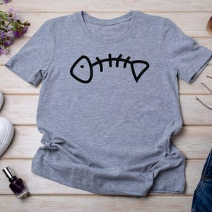 May include: Gray short-sleeved t-shirt with a black fishbone graphic.