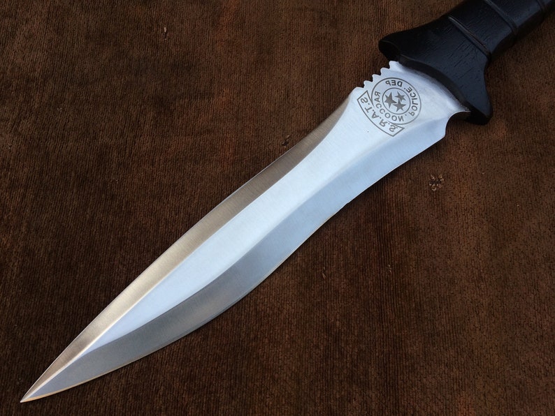 May include: A silver knife with a black handle. The handle has a circular emblem with the text "Raccoon Police Dept."