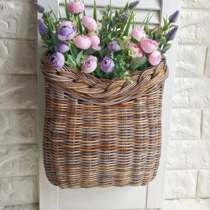 Basket on the door. Rounded flower basket. Wicker basket of motley color, decoration of the front door. Hanging basket on the door. image 2