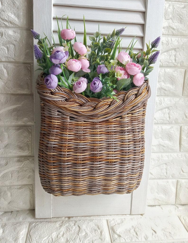 Basket on the door. Rounded flower basket. Wicker basket of motley color, decoration of the front door. Hanging basket on the door. image 2