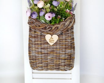 Basket on the door. Rounded flower basket. Wicker basket of motley color, decoration of the front door. Hanging basket on the door.