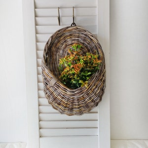 Basket on the door. Oval flower basket.Front door decoration. Straw-colored wicker basket, front door decoration.Hanging basket on the door. 1
