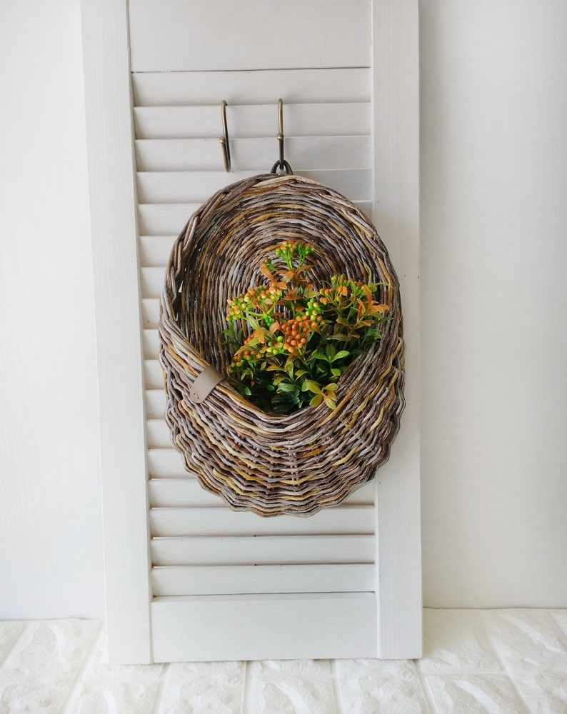 Basket on the door. Oval flower basket.Front door decoration. Straw-colored wicker basket, front door decoration.Hanging basket on the door. 1