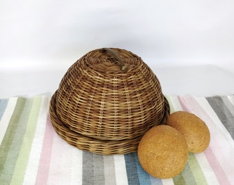 Wicker basket for beautiful serving and storage of bread.Round tray with lid for serving and storing food. Kitchen table setting.