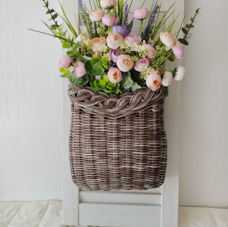 Basket on the door. Rounded flower basket. Wicker basket of motley color, decoration of the front door. Hanging basket on the door. image 3
