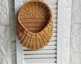 Basket on the door. Oval flower basket.Front door decoration. Straw-colored wicker basket, front door decoration.Hanging basket on the door.