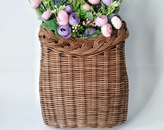 Basket on the door.Basket + flowers in pink-violet tones. Brown wicker basket, front door decoration. Hanging basket on the door.