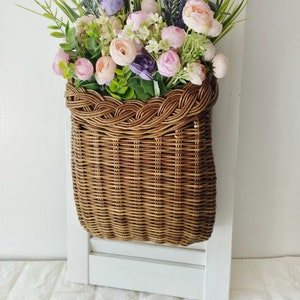 Basket on the door. Rounded flower basket. Wicker basket of motley color, decoration of the front door. Hanging basket on the door. image 4