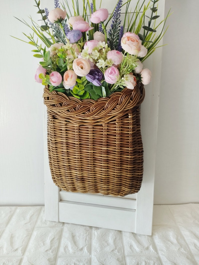 Basket on the door. Rounded flower basket. Wicker basket of motley color, decoration of the front door. Hanging basket on the door. image 4