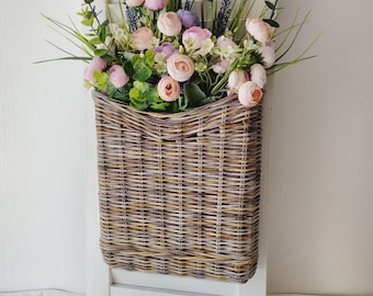 Basket on the door for flowers. Rectangular flat flower basket. Wicker basket in natural color, front door decoration. Hanging basket .