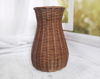 Wicker vase for flowers. Basket for artificial flowers or dried flowers. Decorative jug for home decoration. Photo props for home.