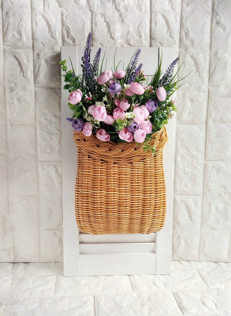 Basket on the door. Rounded flower basket. Wicker basket of motley color, decoration of the front door. Hanging basket on the door. image 1