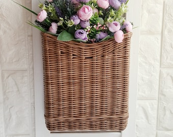 Basket on the door for flowers. Rectangular flat flower basket. Wicker basket in natural color, front door decoration. Hanging basket .