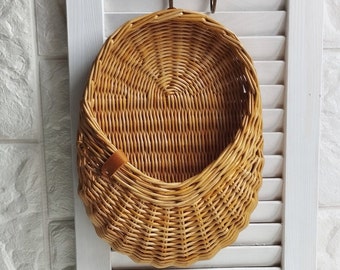 Basket on the door. Oval flower basket.Front door decoration. Straw-colored wicker basket, front door decoration.Hanging basket on the door.