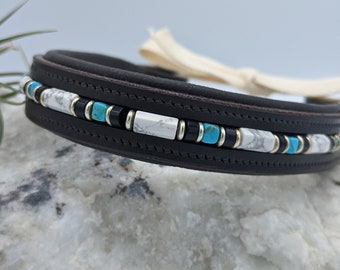 May include: A brown leather dog collar with a decorative band of turquoise, white and black beads.