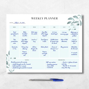 May include: A weekly planner with a light blue background and a watercolor design of leaves in the top right corner. The planner is divided into seven columns for each day of the week, with a section for notes and priorities. The planner includes a list of tasks for each day, such as sending a spreadsheet to Dan, making a breakfast smoothie, writing copy for a website, dropping Max off at daycare, and preparing overnight oats.