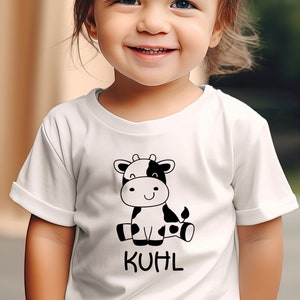 Könnte beinhalten: Ein weißes T-Shirt mit einer schwarz-weißen Comic-Kuh-Illustration und dem Wort "KUHL" auf der Vorderseite.