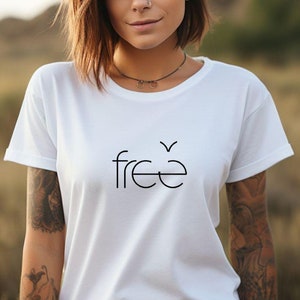 Könnte beinhalten: Ein weißes T-Shirt mit dem Wort "free" in Schwarz auf der Vorderseite. Das Shirt hat ein schlichtes Design und eine lockere Passform.