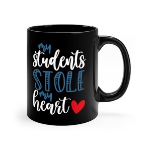 May include: Black ceramic coffee mug with white text that reads "my students stole my heart" with a red heart.