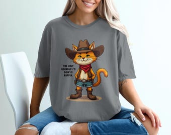 May include: Gray t-shirt featuring a cartoon cat dressed as a cowboy, complete with a hat, vest, and boots. The cat has an orange and white coat and a red bandana. Text on the shirt reads, "The only roundup I'm doin' is nappin."