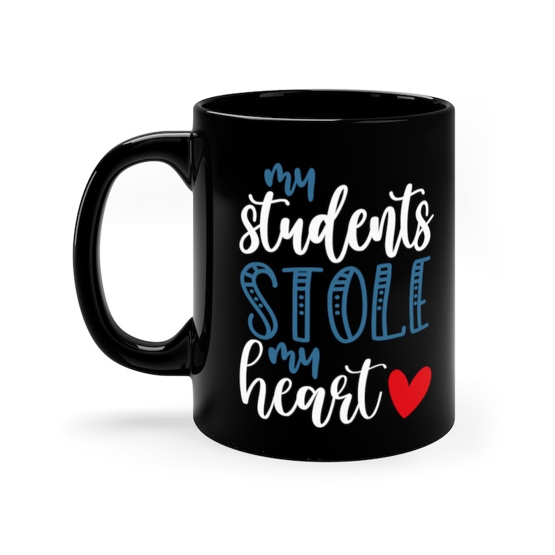 May include: Black ceramic coffee mug with white text that reads "my students stole my heart" with a red heart.