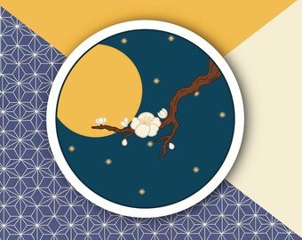 May include: A round sticker depicting a night scene with a full yellow moon, a flowering branch, and stars. The sticker has a white border and is set against a background of blue geometric patterns, yellow, and cream colours.