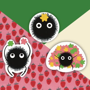 May include: Three black and white cartoon stickers of a fluffy creature with large eyes. The creature is wearing a crown of stars in one sticker, holding two stars in another sticker, and is surrounded by stars in the third sticker.