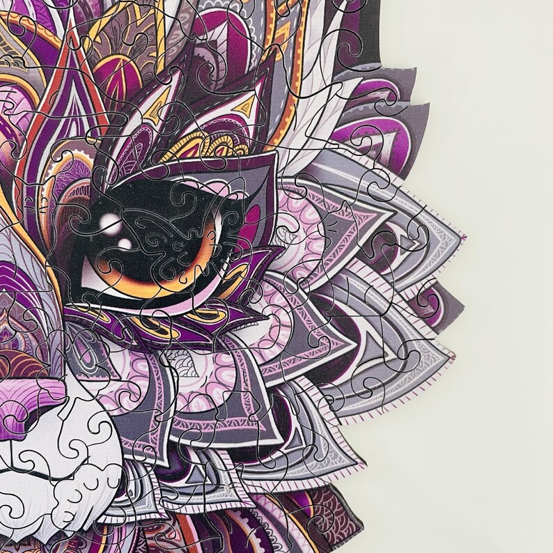 May include: A purple, gray, and white mandala-style jigsaw puzzle piece with intricate details. The piece features a large eye with a yellow iris and a black pupil.