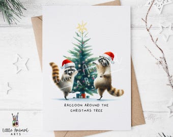 May include: A Christmas card featuring two raccoons wearing Santa hats, dancing around a decorated Christmas tree. The card has the text "RACCOON AROUND THE CHRISTMAS TREE" and is set against a white background.