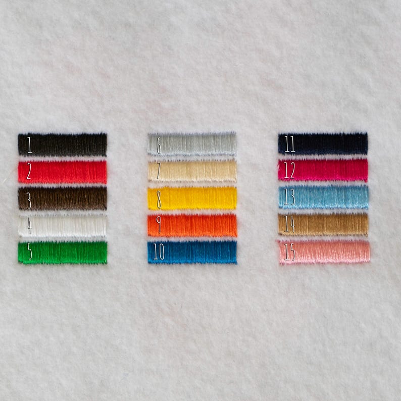 May include: Fifteen embroidered thread samples in a range of colours: black, red, brown, white, green, grey, beige, yellow, orange, blue, navy, fuchsia, turquoise, gold, and pink. Each sample is numbered.