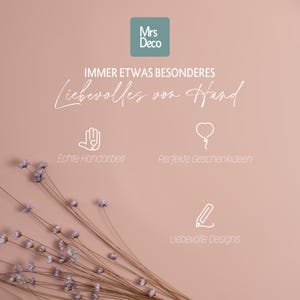 Peut inclure: Fond rose avec le texte "Mrs Deco" dans un carr&eacute; turquoise. Les mots "IMMER ETWAS BESONDERES" et "Liebevolles von Hand" sont &eacute;crits en script blanc. L'image comprend &eacute;galement les phrases "Echte Handarbeit", "Perfekte Geschenkideen" et "Liebevolle Designs".