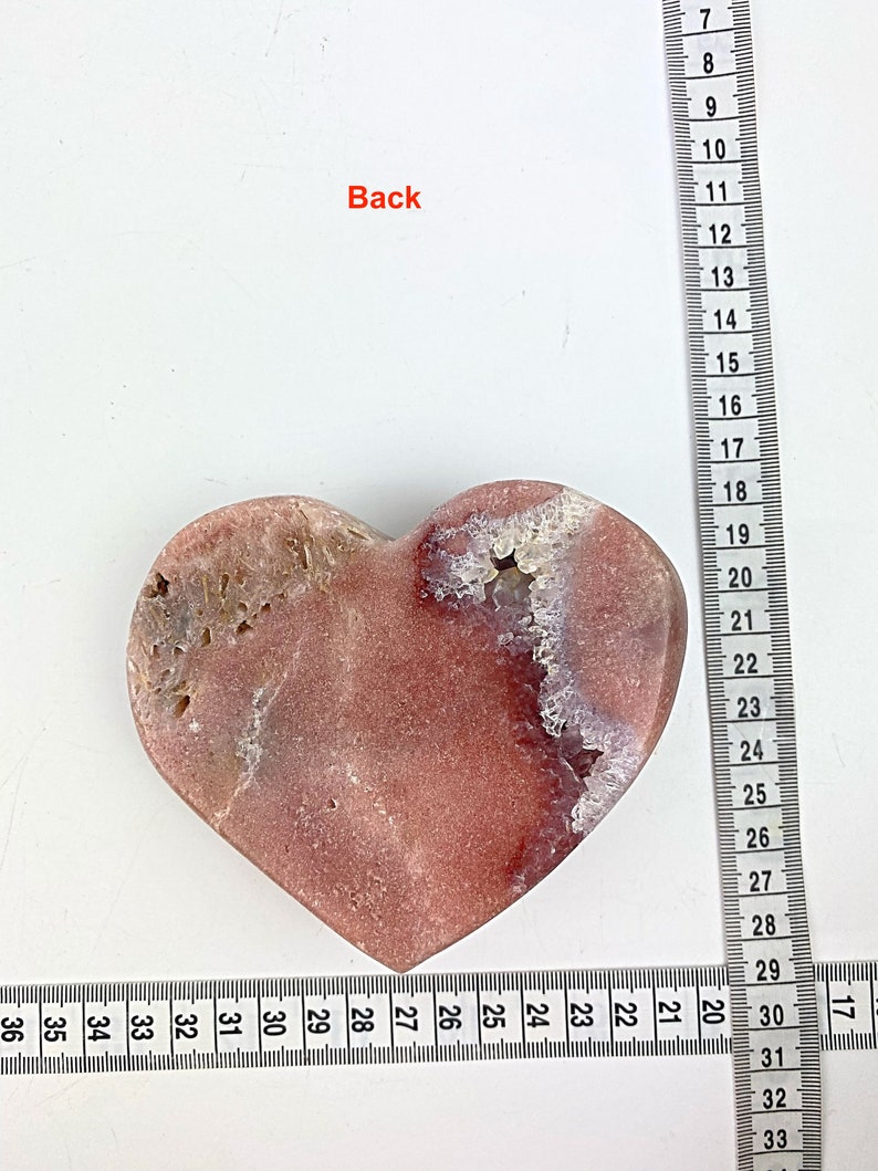 May include: A heart-shaped pink and white agate stone with a rough, natural texture. The stone is approximately 7 inches wide and 6 inches tall.