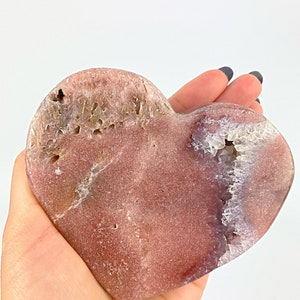 May include: A heart-shaped pink and white agate crystal with a natural druzy formation. The crystal is polished and has a smooth surface.
