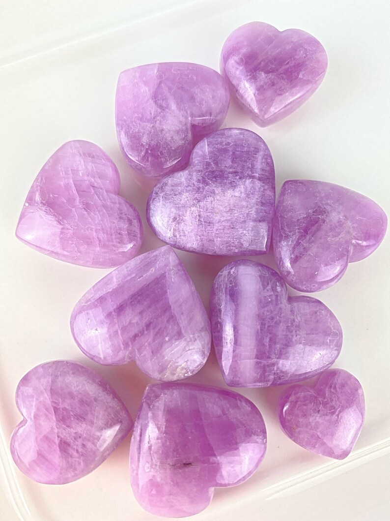 May include: A collection of ten heart-shaped polished selenite crystals in various shades of purple.