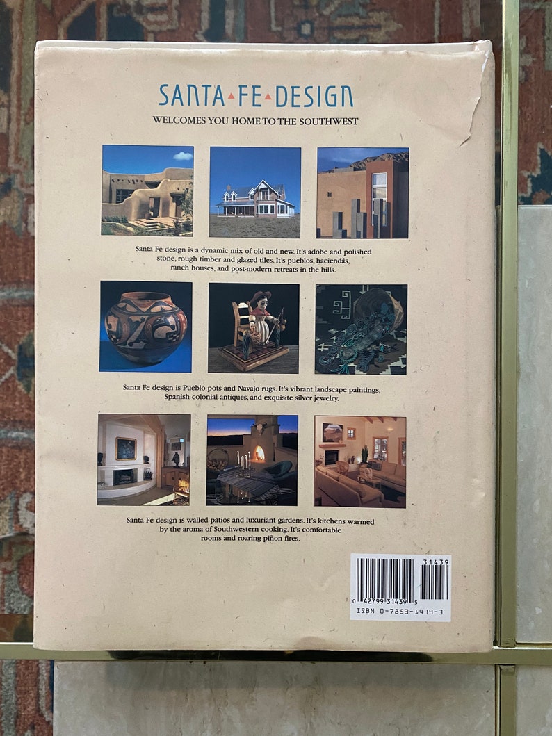May include: A book cover with the title "Santa Fe Design" and a description of the design style. The cover features three images of homes in the southwestern style, with adobe walls, tiled roofs, and lush landscaping.