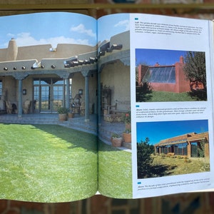May include: A book open to a page with a picture of a house with a large yard and a description of the house's design. The text on the page describes the house's design and the use of natural materials.