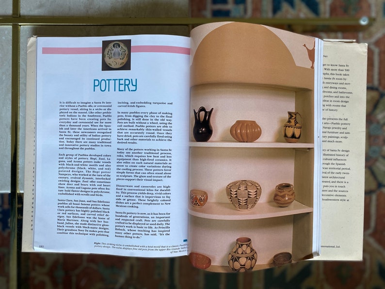 May include: A close-up of a shelf displaying a collection of Pueblo pottery. The pottery is made in various colors and patterns, including black, white, and brown. The pottery is arranged in a decorative manner on the shelf, which is made of wood and has a light brown finish.