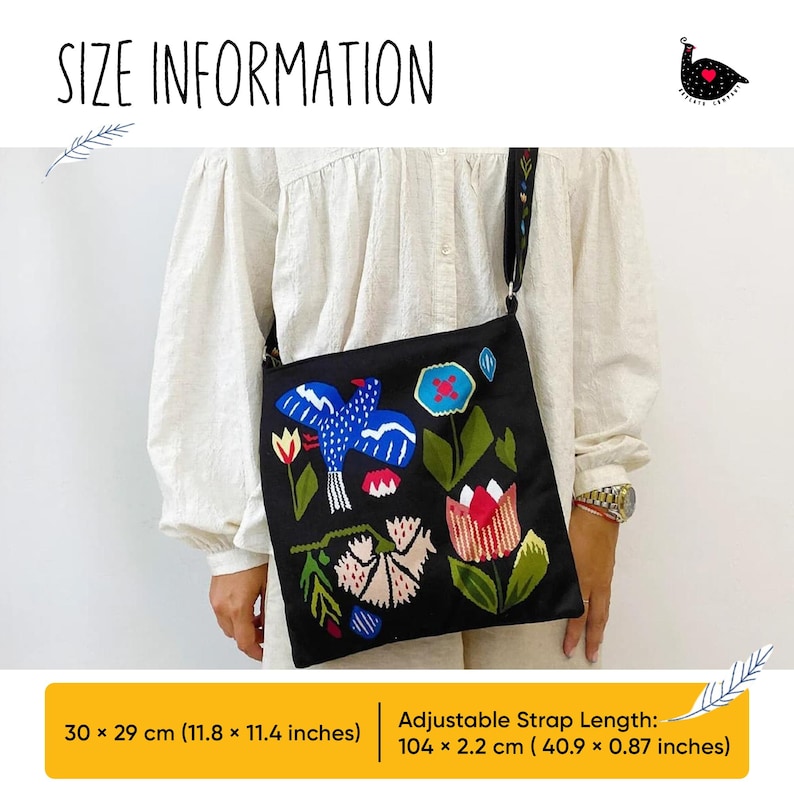a woman holding a black bag with flowers on it