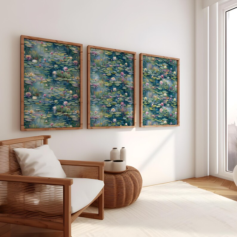 Op de afbeelding: Drie ingelijste wandkunstwerken met een aquarel schilderij van een vijver met waterlelies en bloemen in tinten blauw, groen en roze. De lijsten zijn gemaakt van lichtbruin hout. Het kunstwerk wordt tentoongesteld in een lichte kamer met een houten stoel en een geweven bijzettafel.