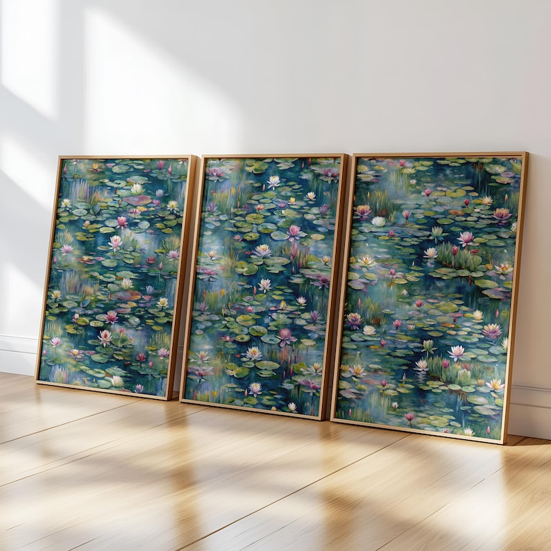 Op de afbeelding: Drie ingelijste kunstdrukken met een aquarel van een vijver vol waterlelies en bloeiende waterlelies. Het kunstwerk heeft een kleurenpalet van teal en groen met roze en witte bloemen. De lijsten zijn lichtbruin.
