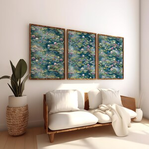 Op de afbeelding: Drie ingelijste wandkunstwerken met een serene waterlelievijver. Het kunstwerk heeft een aquarel stijl met tinten blauw, groen en roze. De lijsten zijn bruin en de kunst hangt boven een witte bank.
