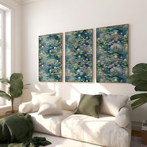 Op de afbeelding: Drie ingelijste kunstwerken die een serene waterlelievijversc&egrave;ne uitbeelden. Het kunstwerk heeft een donkerblauwe achtergrond met gedetailleerde illustraties van waterleliebladeren, roze en witte bloemen en lange groene rietstengels. De frames hebben een gouden afwerking.
