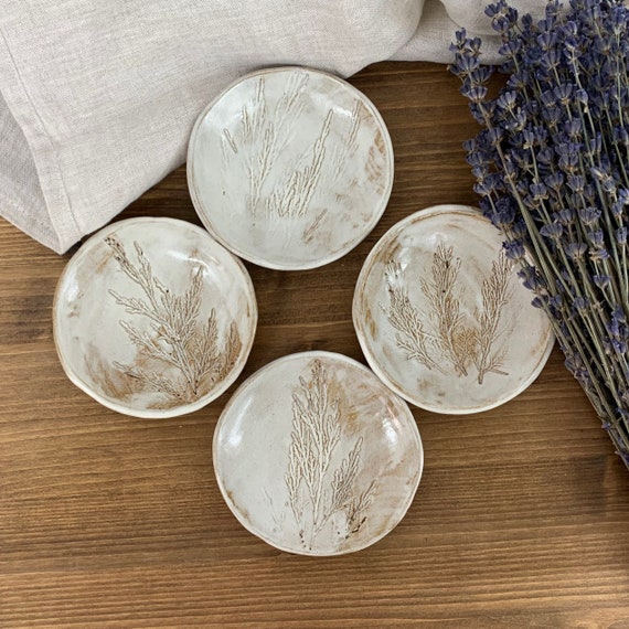 A curated set of earthy, organically-shaped handmade pottery bowls with 70 favorites — this is exactly the 'a real person made this' stocking stuffer energy.