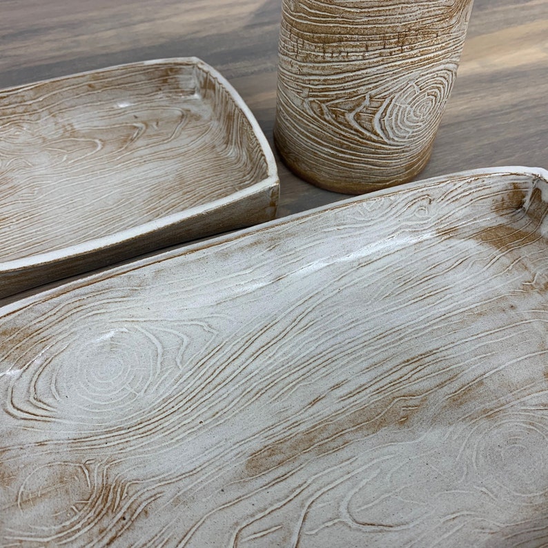 close up of two wood-patterned trays and cup sitting on table