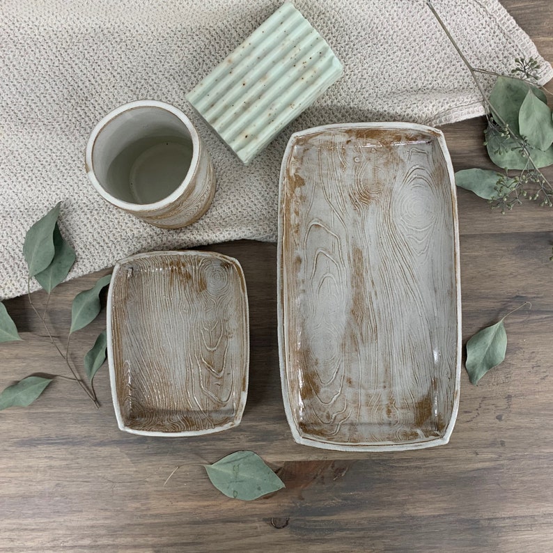 two wood-patterned trays and cup sitting on table