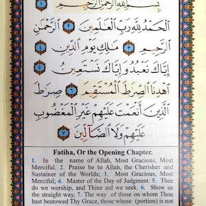 May include: A page from the Quran, the Islamic holy book, with Arabic text in black ink on a white background. The text is surrounded by a decorative border in shades of blue, green, and pink. The page is titled "Fatiha, Or the Opening Chapter." and includes an explanation of the different types of pronunciation in Arabic.