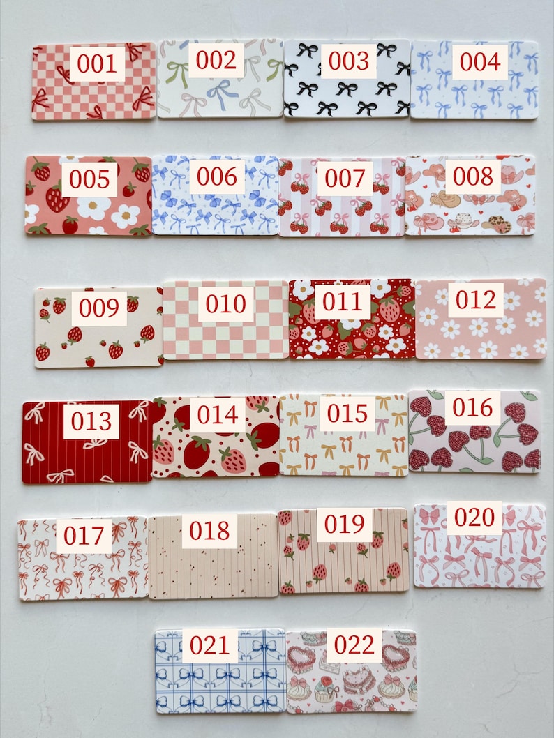 May include: A collection of 22 rectangular cards with various patterns and the numbers 001-022 printed on them. Designs include bows, strawberries, cherries, and floral patterns in colors like red, pink, and blue.