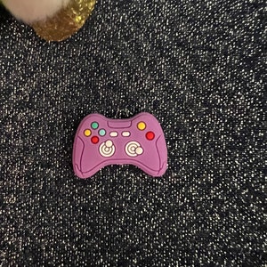 May include: Purple video game controller charm with colorful buttons.