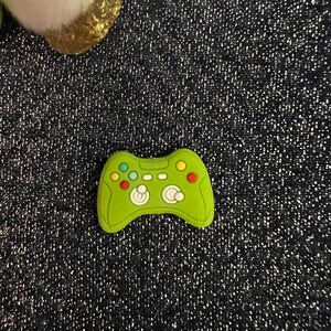 May include: A green plastic toy game controller with colorful buttons.