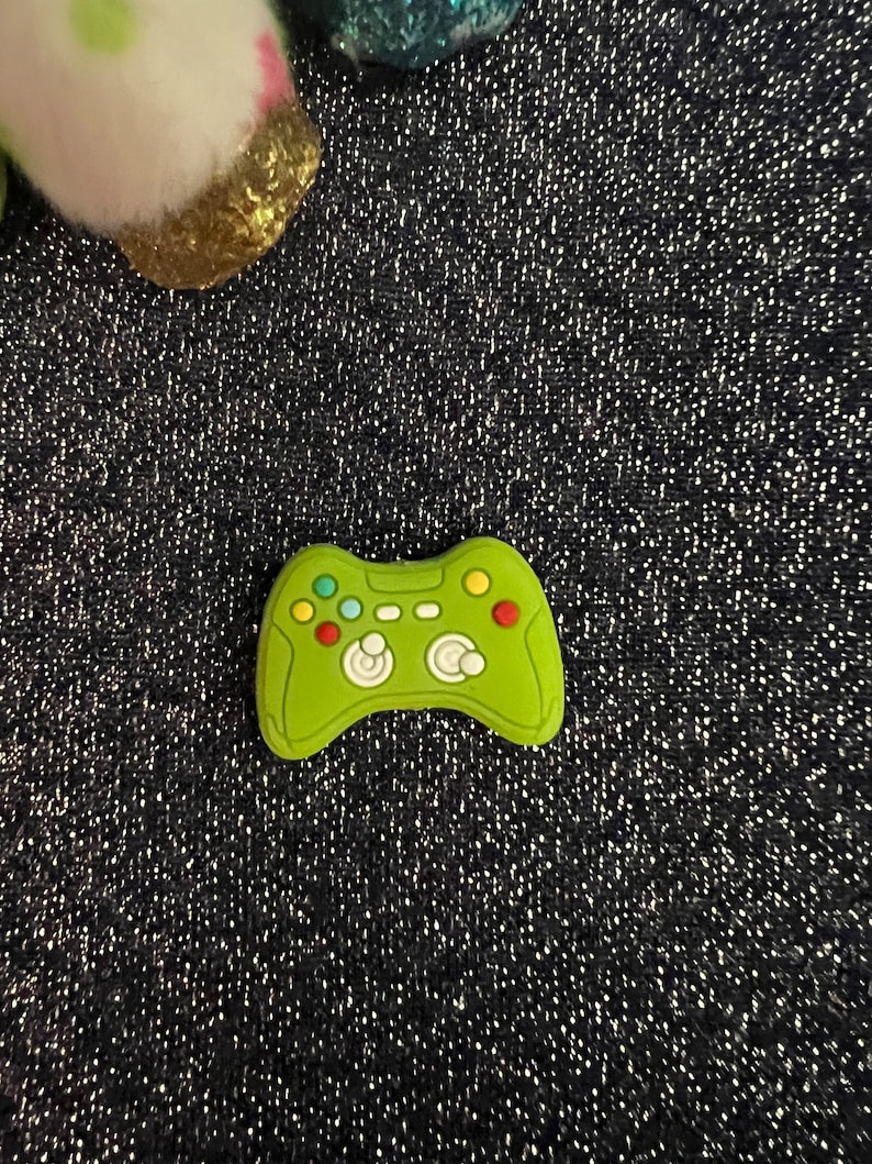 May include: A green plastic toy game controller with colorful buttons.